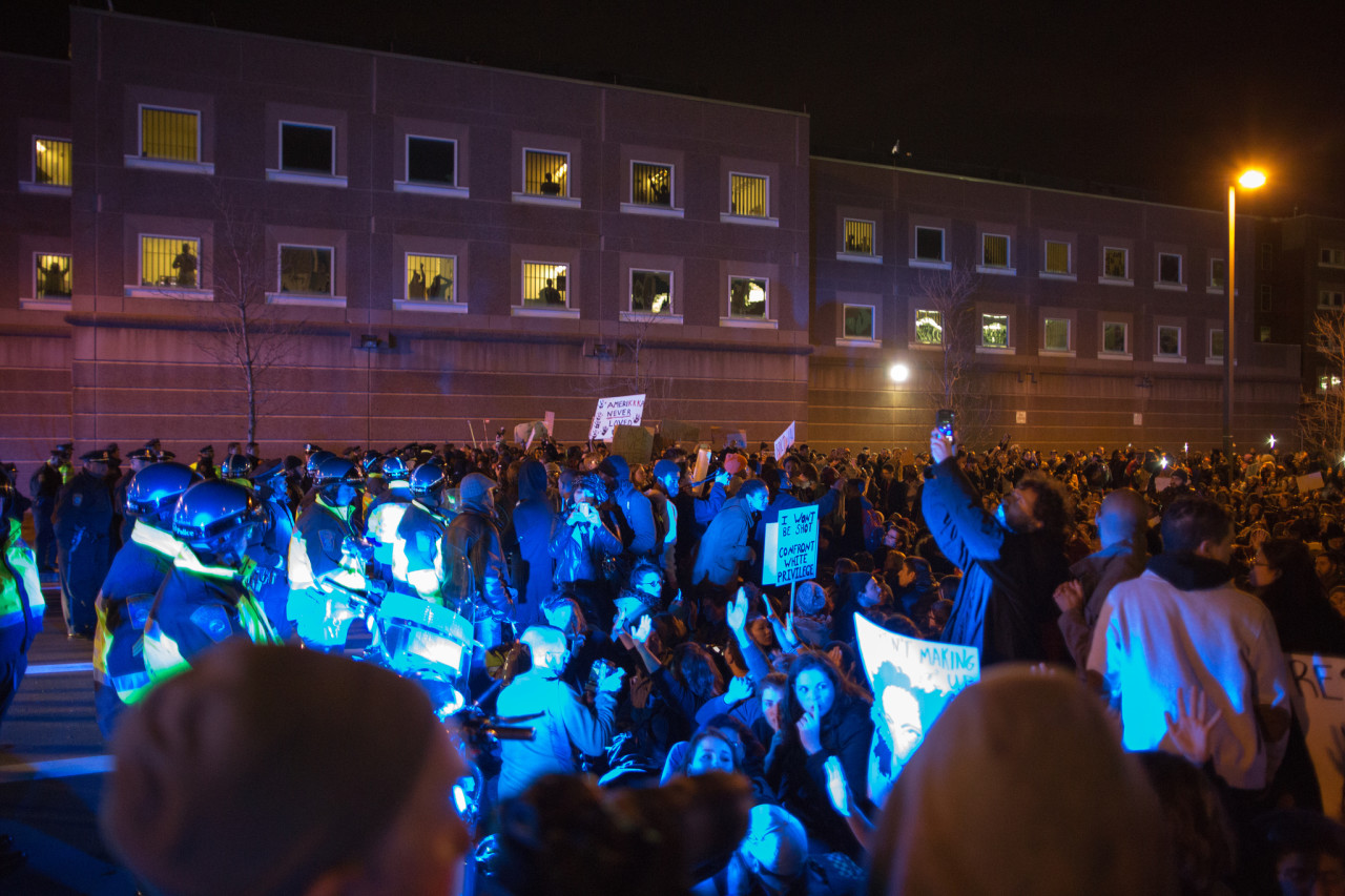 Protesters gathered outside the South Bay Corrections facility, with inmates looking out of barred windows. (Joe Spurr/WBUR)