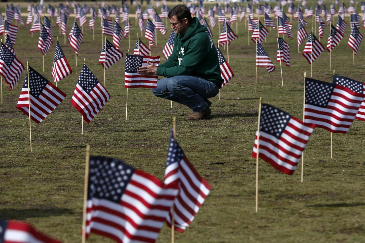 On March 27, Navy veteran Jeff Hensley of Dallas, Texas, now with Iraq and Afghanistan Veterans of America (IAVA), joins others in placing flags representing veteran and service members who have died by suicide. 
