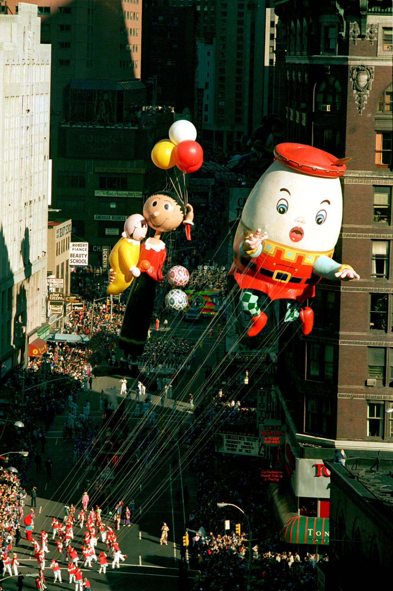 A new Humpty Dumpty balloon, followed by a redesigned Olive Oyl holding Swee' Pea, floats down Broadway in 1986.  (Ron Frehm/AP)
