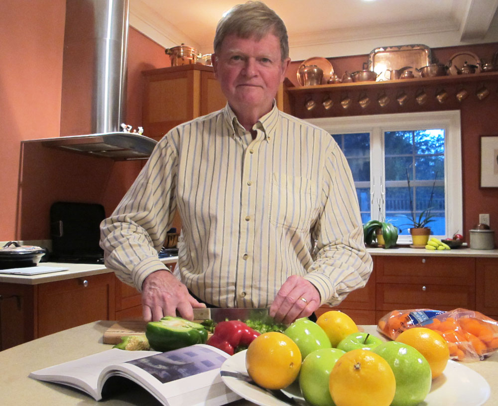 Boston Printmakers board member David Thomas, who helped organize "Palate to Plate,” slices a green pepper in his kitchen. (Andrea Shea/WBUR)