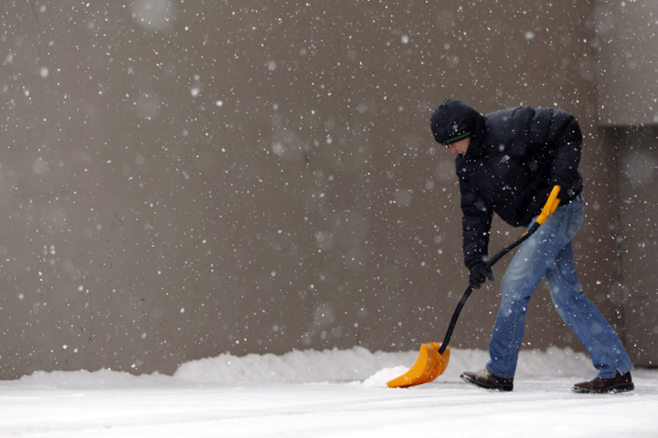 Cole Baldock works to clear snow , Wednesday morning, Nov. 12, 2014, in Denver. A powerful storm made up of the remnants of Typhoon Nuri moved into the intermountain West on Monday and has settled across the central part of the country, plunging temperatures below zero in some locations and dropping a light snow that has snarled traffic. (AP)