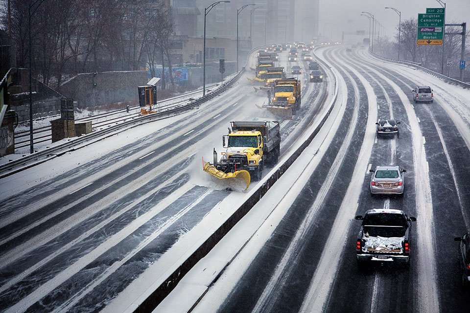 A row of snowplows moves down I-90 in Boston during the first snowstorm of 2014. (Jesse Costa/WBUR)