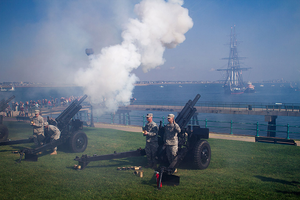 The USS Constitution faces Castle Island during a 21-gun salute on what was the final voyage around Boston Harbor before the ship went into drydock for restoration. (Jesse Costa/WBUR)
