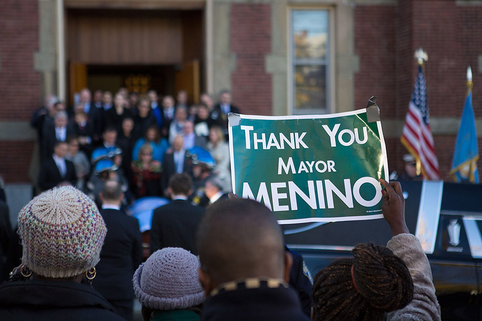 Someone holds “Thank You Mayor Menino” as Angela Menino, Mayor Thomas Menino’s wife of 48 years, and family stand in front of his casket outside of the Most Precious Blood Parish following the funeral service. (Jesse Costa/WBUR)