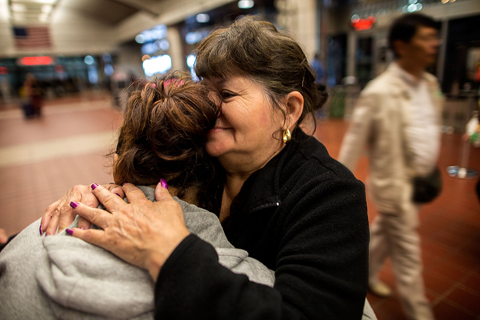 Lisette, left, is seeking asylum in the U.S. She fled El Salvador, with a daughter, on July 12, and arrived at Boston’s South Station, where she was embraced by her aunt, on Oct. 7. (Jesse Costa/WBUR)
