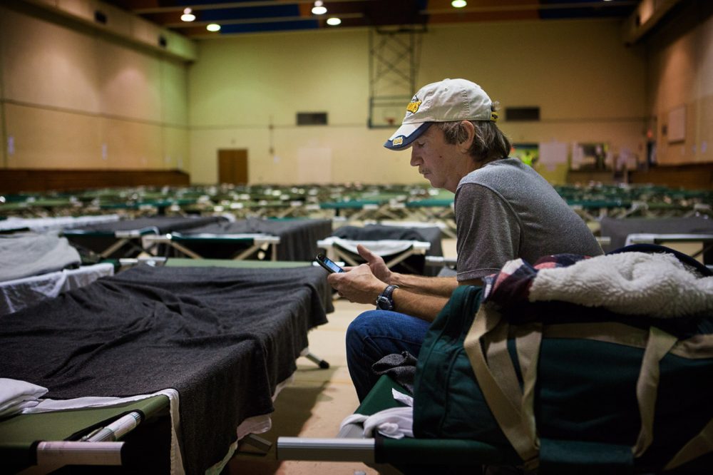 A man who did not want to be identified sits on a cot in a temporary shelter set up by the Boston Public Health Commission following the Long Island bridge closure. (Jesse Costa/WBUR)