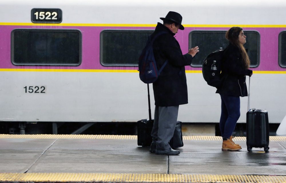 Passengers wait to board a train at South Station in Boston on Nov. 26. (Michael Dwyer/AP)