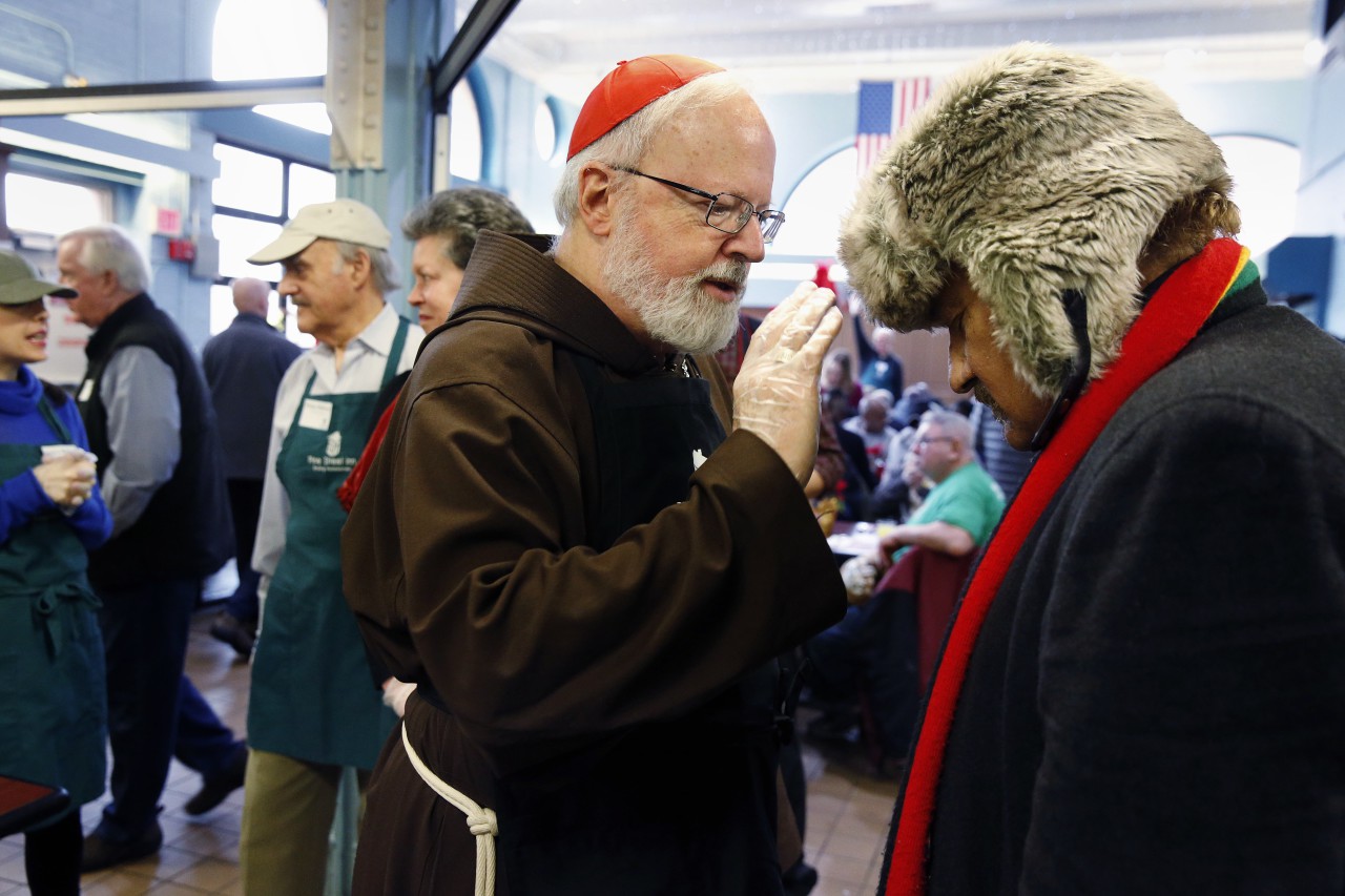Archbishop of Boston Sean O&#039;Malley administers a blessing while serving meals at the Pine Street Inn homeless shelter in Boston  Wednesday. (Michael Dwyer/AP)