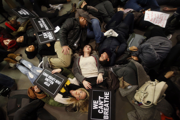 Protesters rallying against a grand jury's decision not to indict the police officer involved in the death of Eric Garner stage a "die-in" at the Apple Store on Fifth Avenue, Friday, Dec. 5, 2014, in New York. (AP)