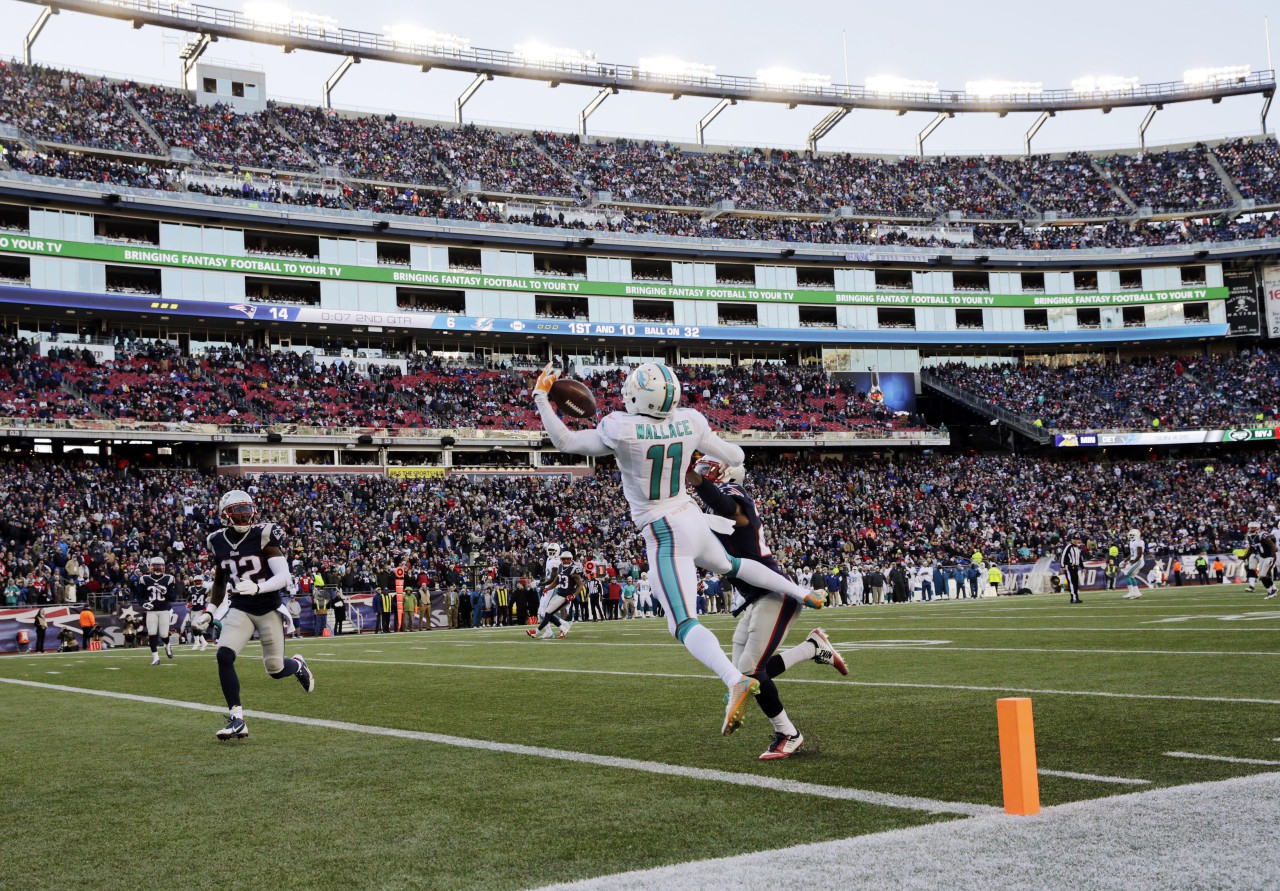 Miami Dolphins wide receiver Mike Wallace (11) catches a touchdown pass in front of New England Patriots defensive back Malcolm Butler, right rear, and safety Devin McCourty (32) in the first half. (Charles Krupa/AP)