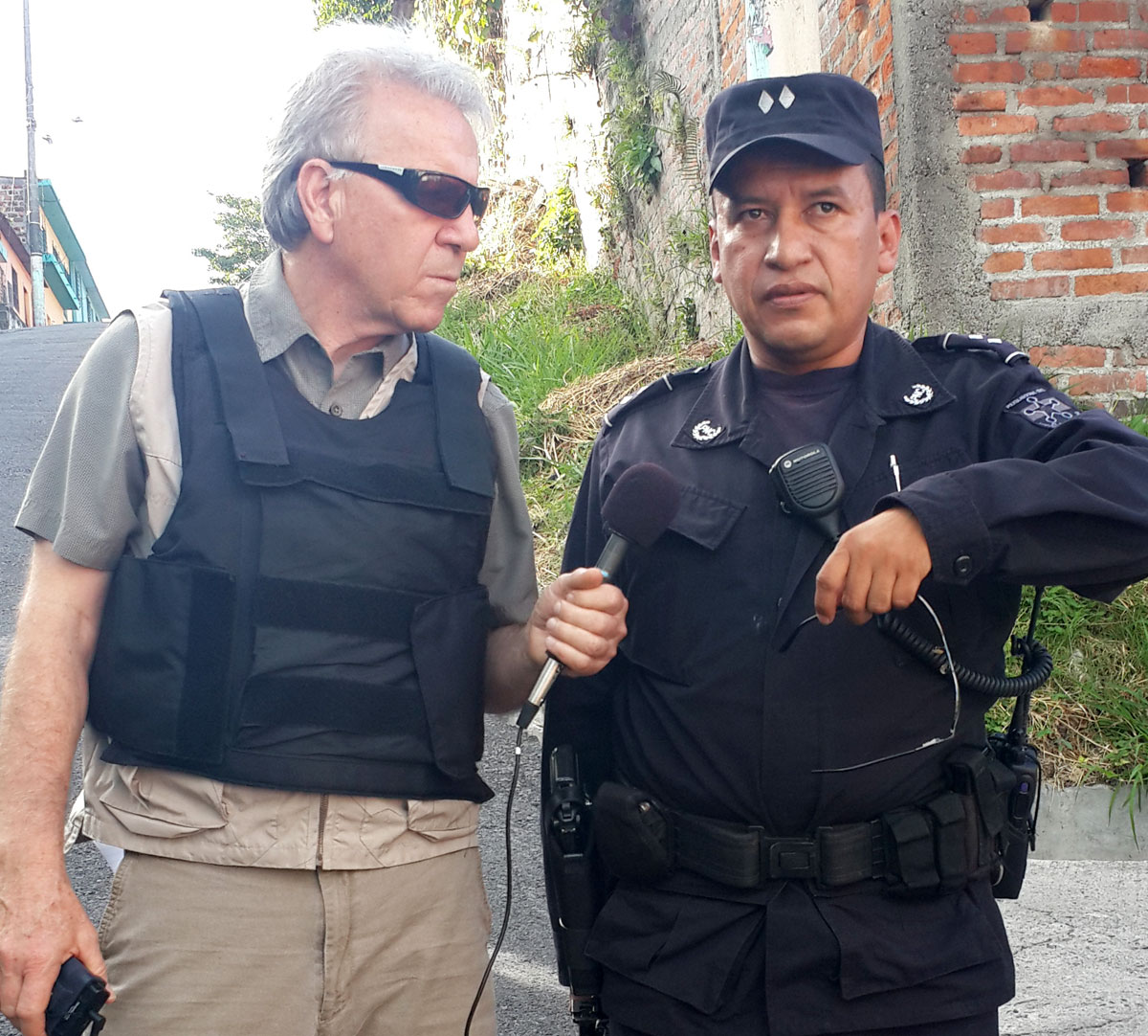 El Salvador National Police Inspector Jorge Alberto Vasquez with WBUR's David Boeri in Mejicanos. He instructed Boeri to wear the bulletproof vest. (Courtesy of Norman Palomo)