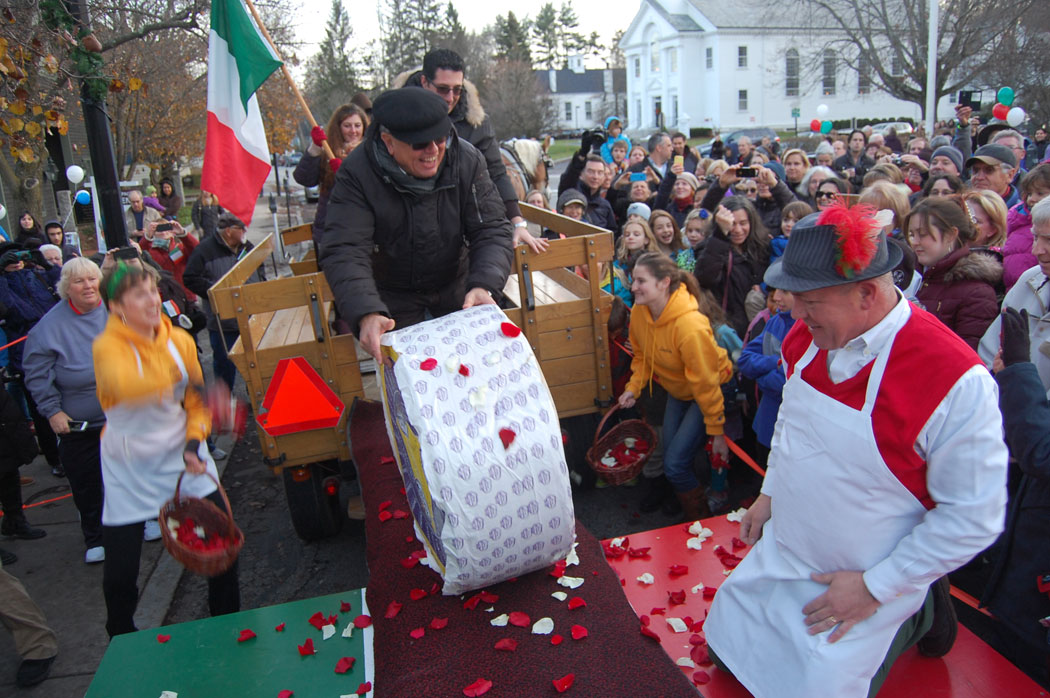 The representative of Rifugio Crucolo wheels the 400-pound cheese off the wagon. (Greg Cook)