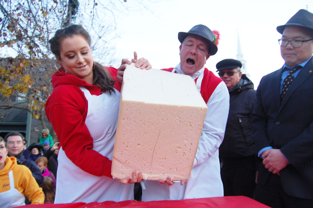 Peter Lovis and an assistant move a massive wedge of the crucolo cheese. (Greg Cook)