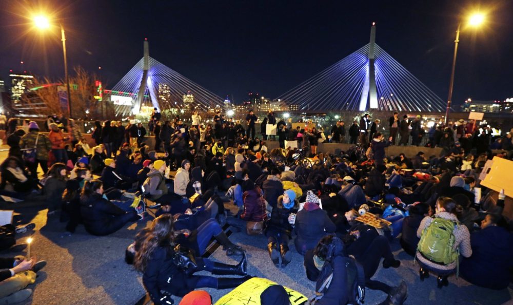 Thousands of protestors sit on the Charlestown Bridge blocking traffic into Downtown Boston during protests Thursday night. (Charles Krupa/AP)
