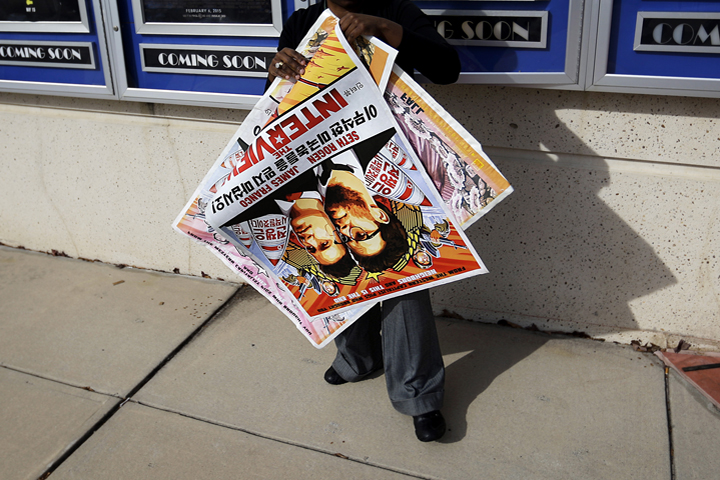 A poster for the movie "The Interview" is carried away by a worker after being pulled from a display case at a Carmike Cinemas movie theater, Wednesday, Dec. 17, 2014, in Atlanta. (AP)