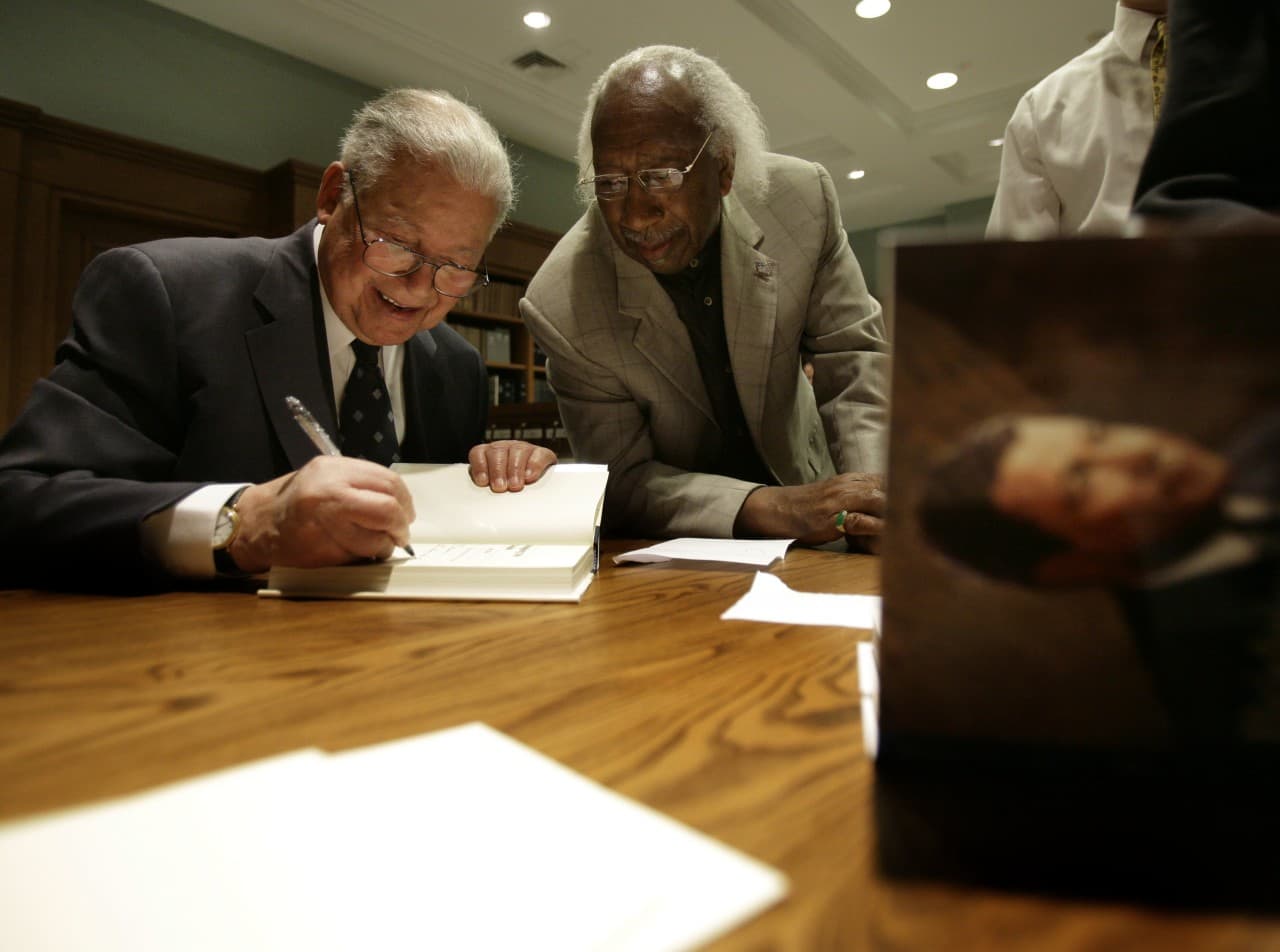 Former Sen. Edward W. Brooke, 86, left, signs a copy of his book "Bridging the Divide: My Life" for Marvin E. Gilmore, JR. at the Massachusetts Historical Society in Boston, 2007. (Michael Dwyer/AP)