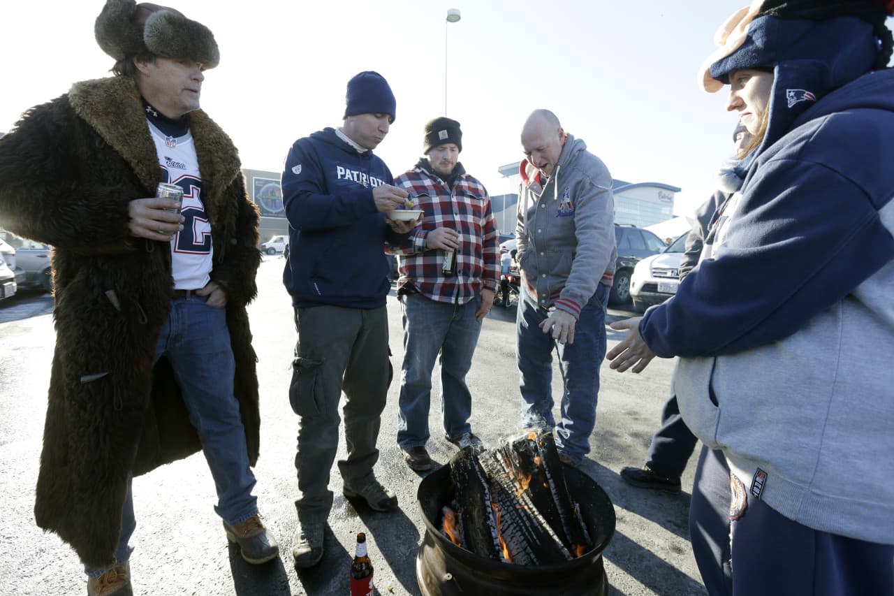 Patriots fans tailgate around a fire in the Gillette Stadium parking lot before the NFL divisional playoff game between the New England Patriots and Baltimore Ravens. (Steven Senne/AP)