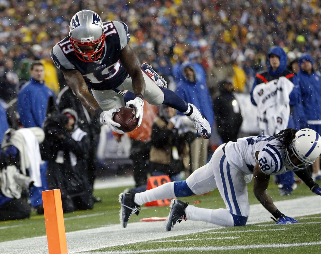 New England Patriots wide receiver Brandon LaFell (19) dives over Indianapolis Colts cornerback Greg Toler (28), but he had stepped out of bounds before reaching the end zone during the second half of the AFC Championship. (Julio Cortez/AP)