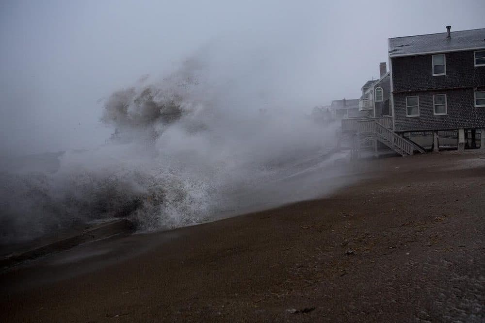 A wave crashes over the sea wall in the Cedar Point area of Scituate, during a January Nor'easter. (Jesse Costa/WBUR)