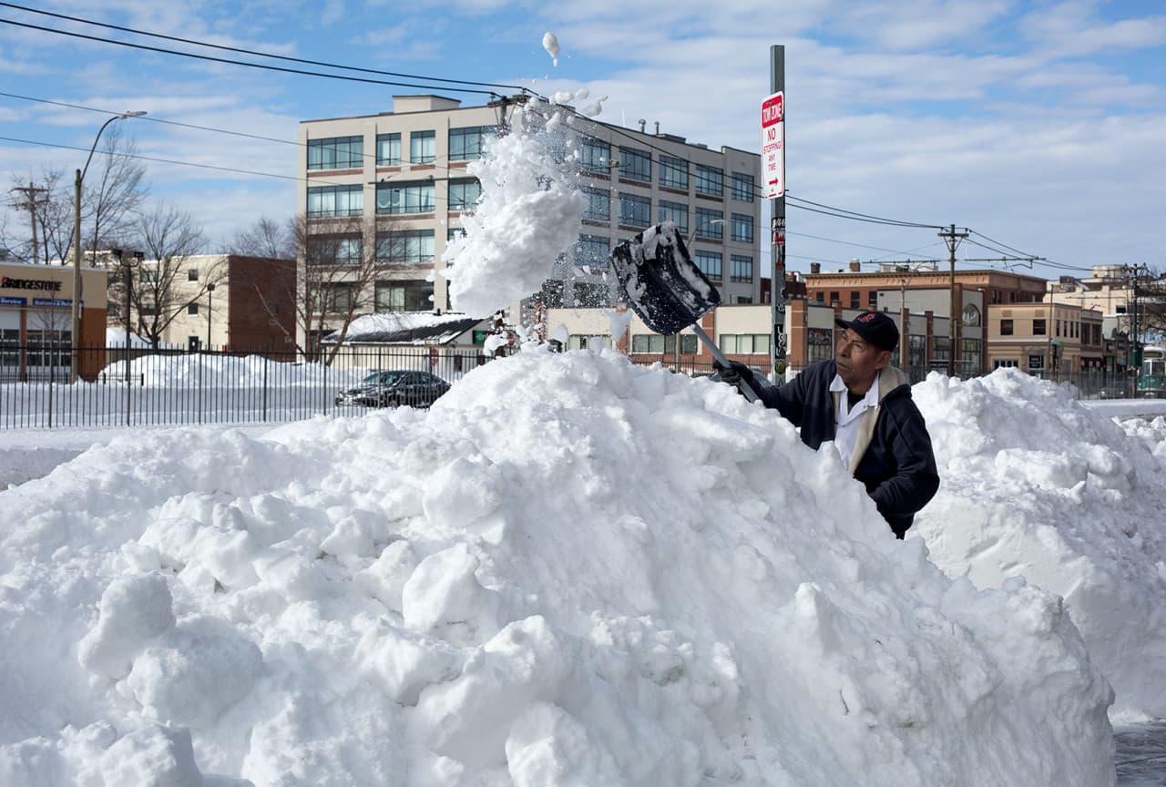 Juan Mendoza shovels snow as businesses prepare to open up on Commonwealth Ave. in Boston. (Robin Lubbock/WBUR)