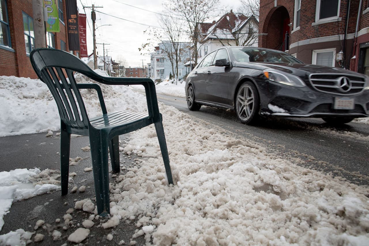 A green plastic chair guards a parking space on Linden St. in Boston. (Robin Lubbock/WBUR)