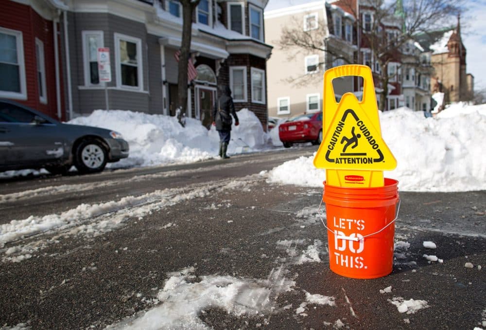 “Caution,” and “let’s do this” seem to send mixed messages to anyone eyeing this parking space on I St. in South Boston. (Robin Lubbock/WBUR)