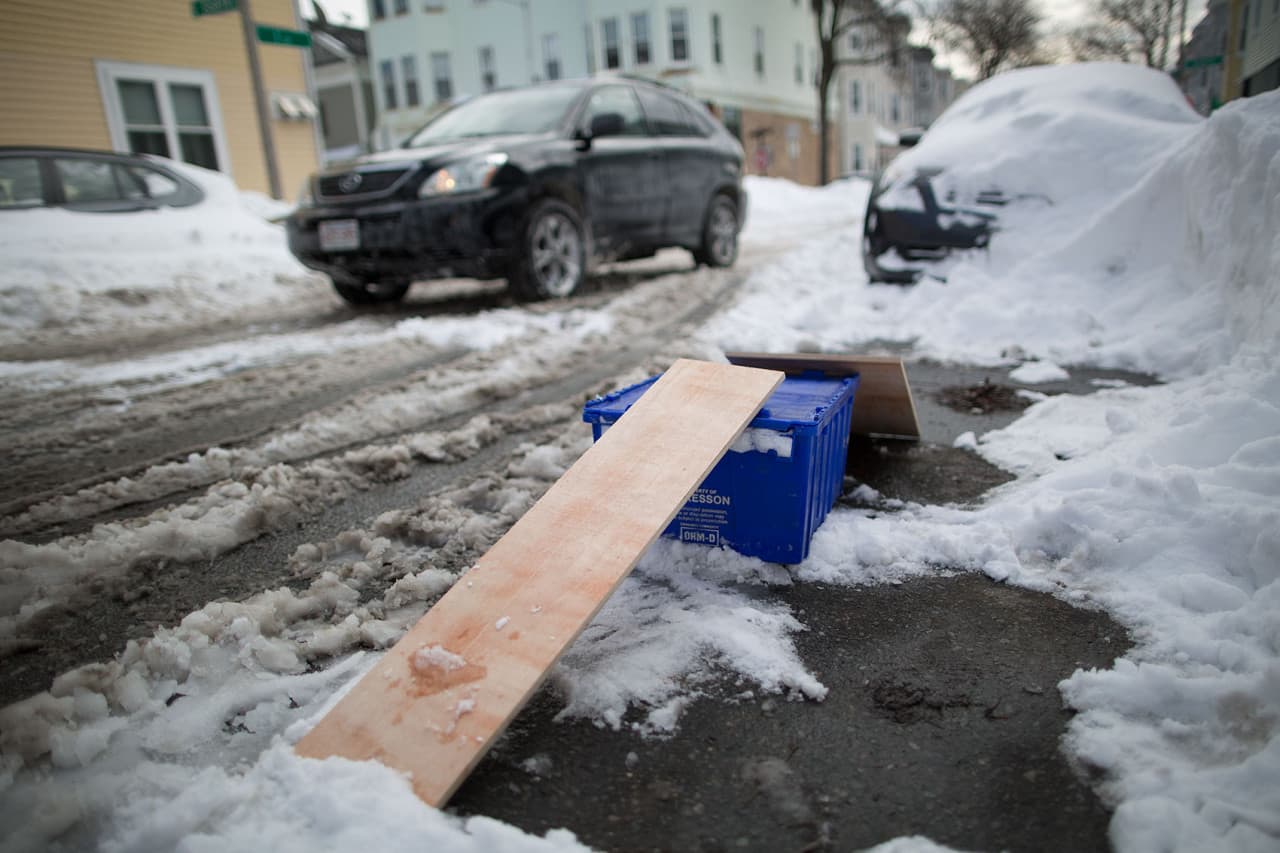 A blue crate and some wood save a parking space in I St. in South Boston. (Robin Lubbock/WBUR)