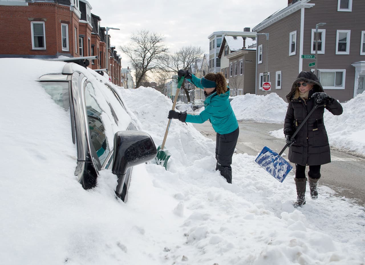 Melissa Anello (left) and Ali Bogdan dig out Bogdan’s car on I St. in South Boston. If you dig yourself out a space, says Anello, “you have the right to save it for a while.” Space saving seems to be less of a concern for Bogdan, who says she won’t be moving her car for a while. (Robin Lubbock/WBUR)