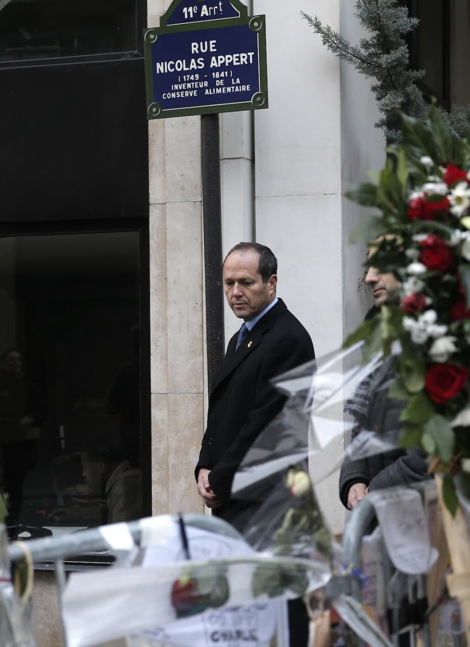 Jerusalem Mayor Nir Barkat, walks past flowers next to Charlie Hebdo newspaper in Paris on Wednesday. (Christophe Ena/AP)