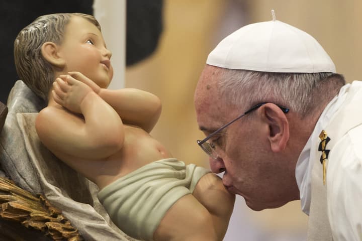 Pope Francis kisses a statue of the baby Jesus as he arrives to celebrate a New Year mass in St. Peter's Basilica at the Vatican in Vatican City Thursday, Jan. 1, 2015.  (AP)