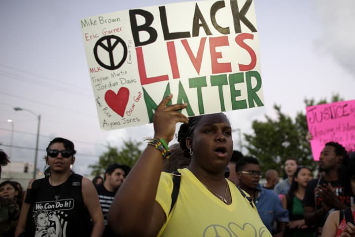 Desiree Griffiths, 31, of Miami, holds up a sign saying "Black Lives Matter", with the names of Michael Brown and Eric Garner, two black men recently killed by police, during a protest Friday, Dec. 5, 2014, in Miami. (AP)
