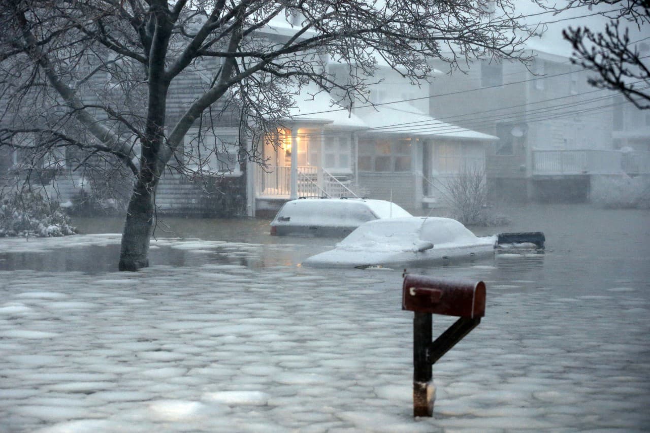 Water floods a street on the coast in Scituate. (Michael Dwyer/AP)