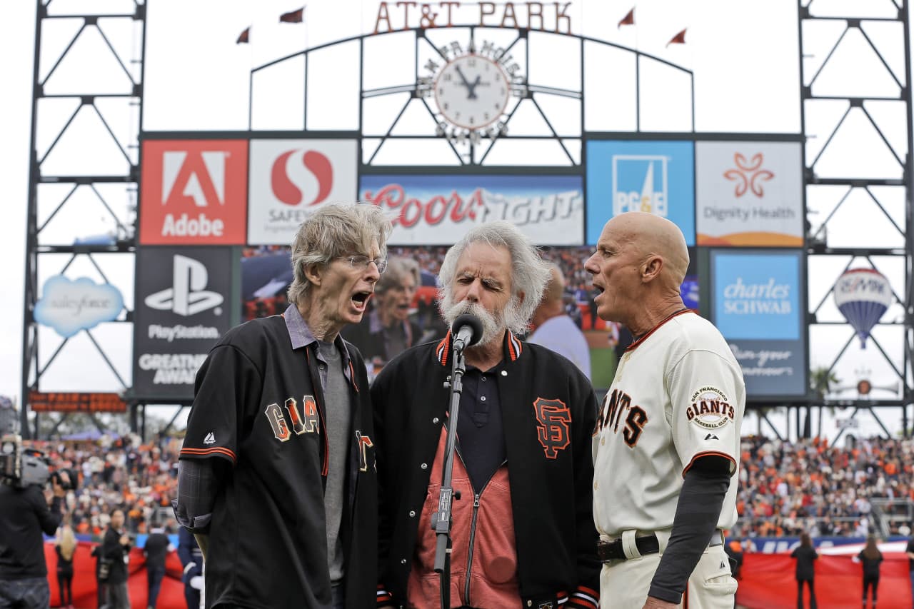 From left to right Grateful Dead's Phil Lesh, and Bob Weir with San Francisco Giants' Tim Flannery sing the national anthem before Game 3 of the National League baseball championship series between the San Francisco Giants and the St. Louis Cardinals on Tuesday, Oct. 14, 2014, in San Francisco. (AP)