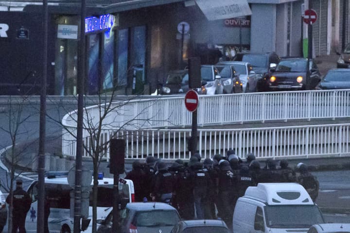 Smoke emanates from the entrance to a kosher market as security forces prepare to end a hostage situation, Paris, Friday, Jan. 9, 2015. Explosions and gunshots were heard as police forces stormed a kosher grocery in Paris where a gunman was holding at least five people hostage. (AP)