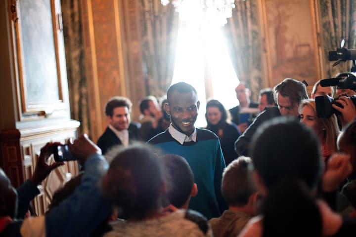 Lassana Bathily, center, talks with children prior to speeched from U.S. Secretary of State John Kerry and Paris' mayor Anne Hidalgo, at the Paris' city hall, Friday, Jan. 16, 2015. The government announced Thursday it would give citizenship to a Malian immigrant who saved several Jewish shoppers last week by hiding them in the kosher market’s basement before sneaking out to brief police on Coulibaly, the hostage-taker upstairs. (AP)