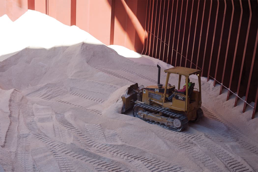 Within a cargo ship’s hold, a bulldozer pushes the salt into piles for cranes to pick up. (Allison Cekala)