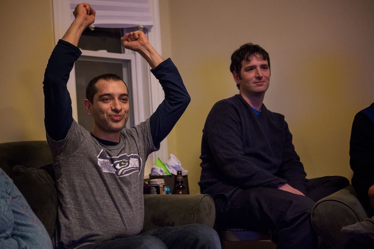 Navad Tanners, left, has called Boston home for seven years but grew up in Spokane, Washington. He hosted a dozen friends for Sunday's Super Bowl game. (Jesse Costa/WBUR)