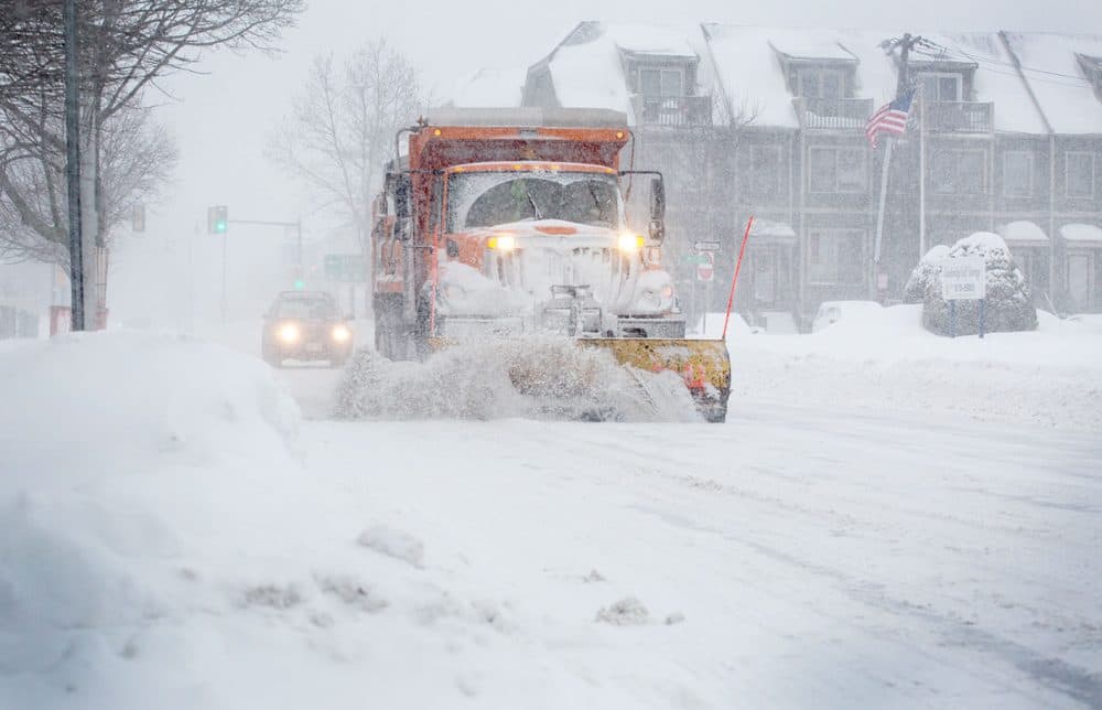 A snow plow works down Concord Avenue during the morning commute. 