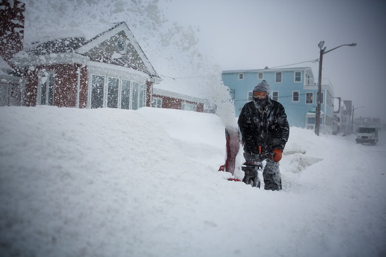 Sean Foley battles whiteout conditions while snowblowing his walkway in Winthrop. (Jesse Costa/WBUR)