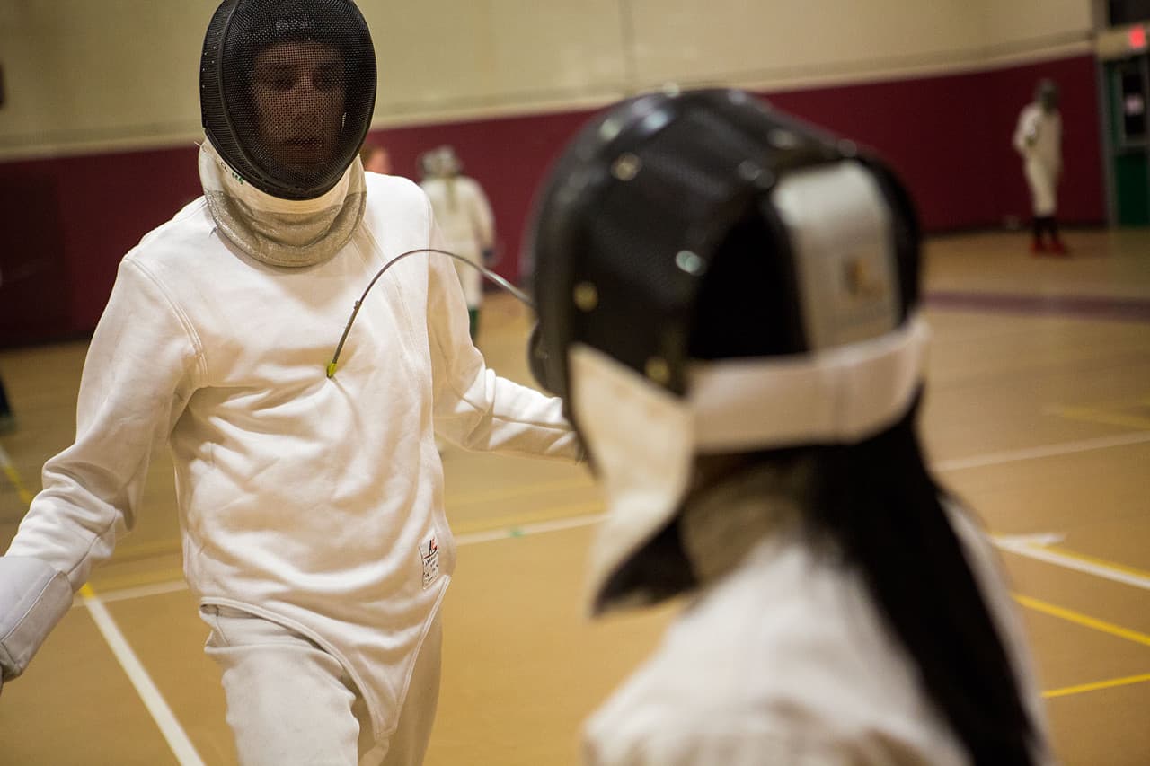 Max Krims is one of the top fencers at CCHS. Here he demonstrates to Natalie Ma what a hit should look like. (Jesse Costa/WBUR)