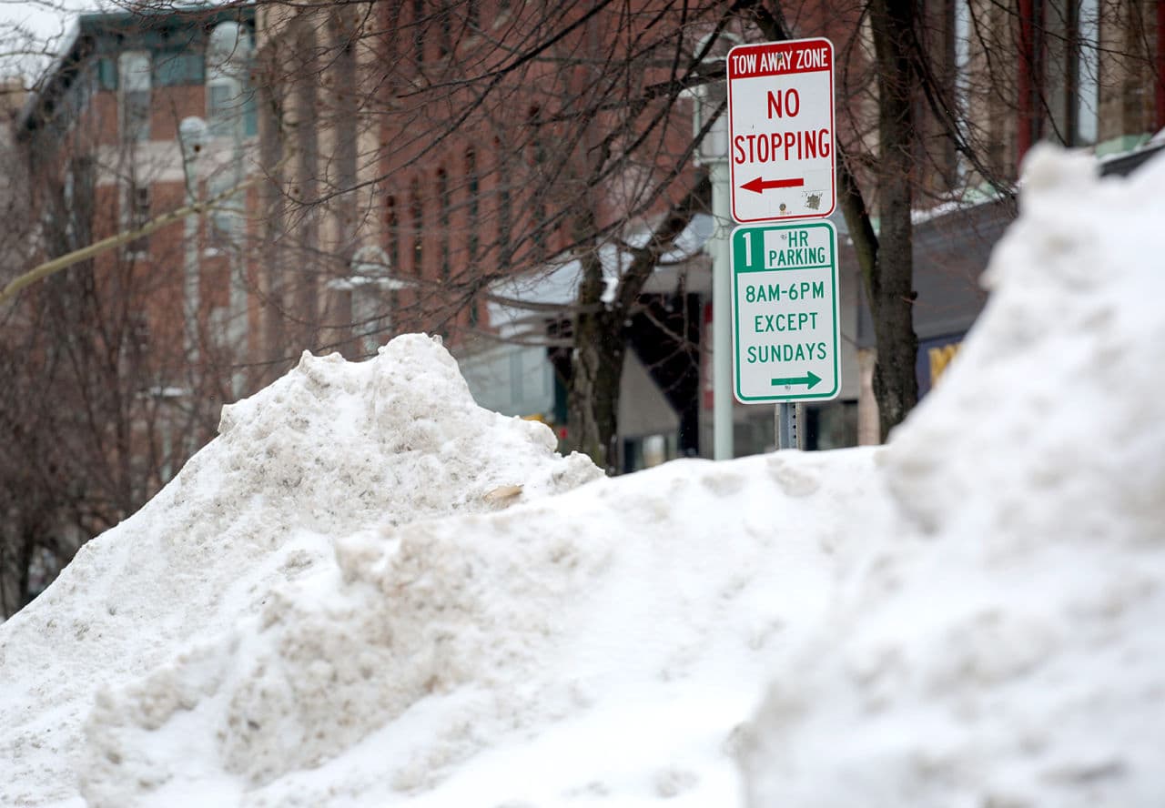 The snow piles in Cambridge nearly covered the street signs Tuesday. (Robin Lubbock/WBUR)