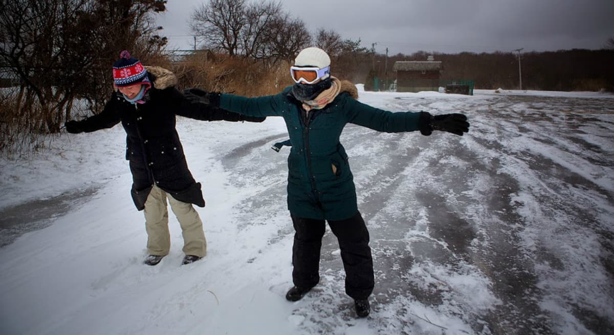 Emily Farr and Cait Simmons, of Scituate, battle winds as they attempt to walk toward Egypt Beach in Scituate, Jan. 27, 2015. (Jesse Costa/WBUR) 