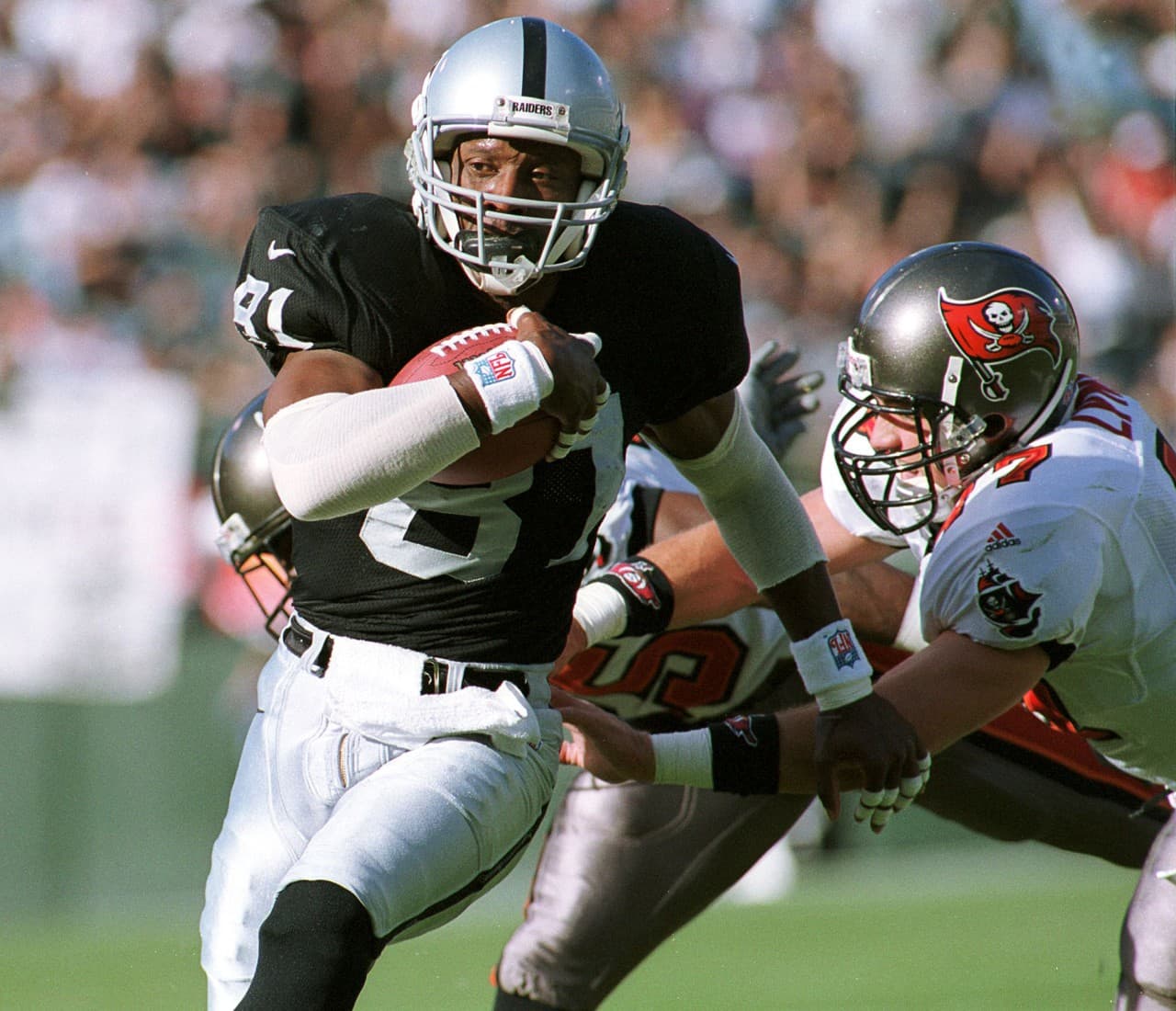 Oakland Raiders wide receiver Tim Brown (L) eludes