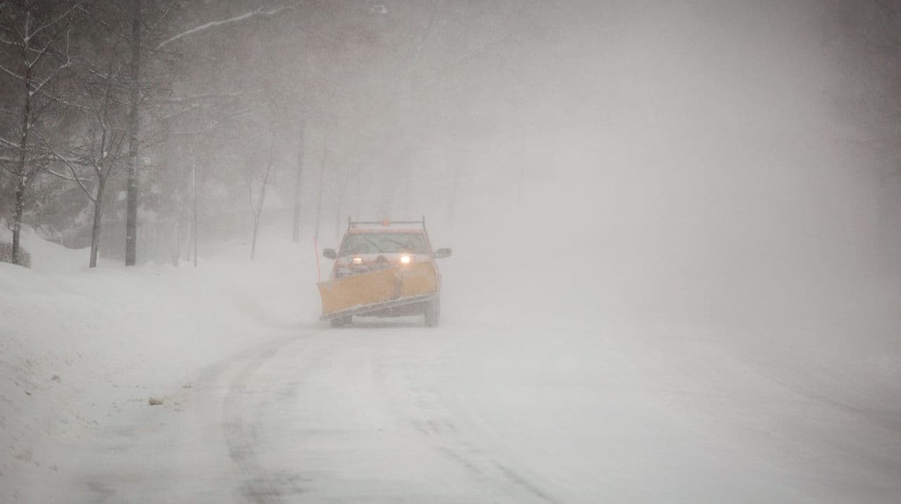 A snow plow drives on Fresh Pond Parkway in Cambridge Sunday morning. (Robin Lubbock/WBUR)