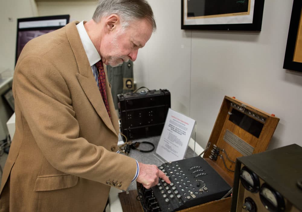 Museum of World War II founder Kenneth Rendell demonstrates how to encode a message using an Enigma machine. Here, as he presses on the “T” on the keyboard, the “X” lights up in the panel above. (Robin Lubbock/WBUR)