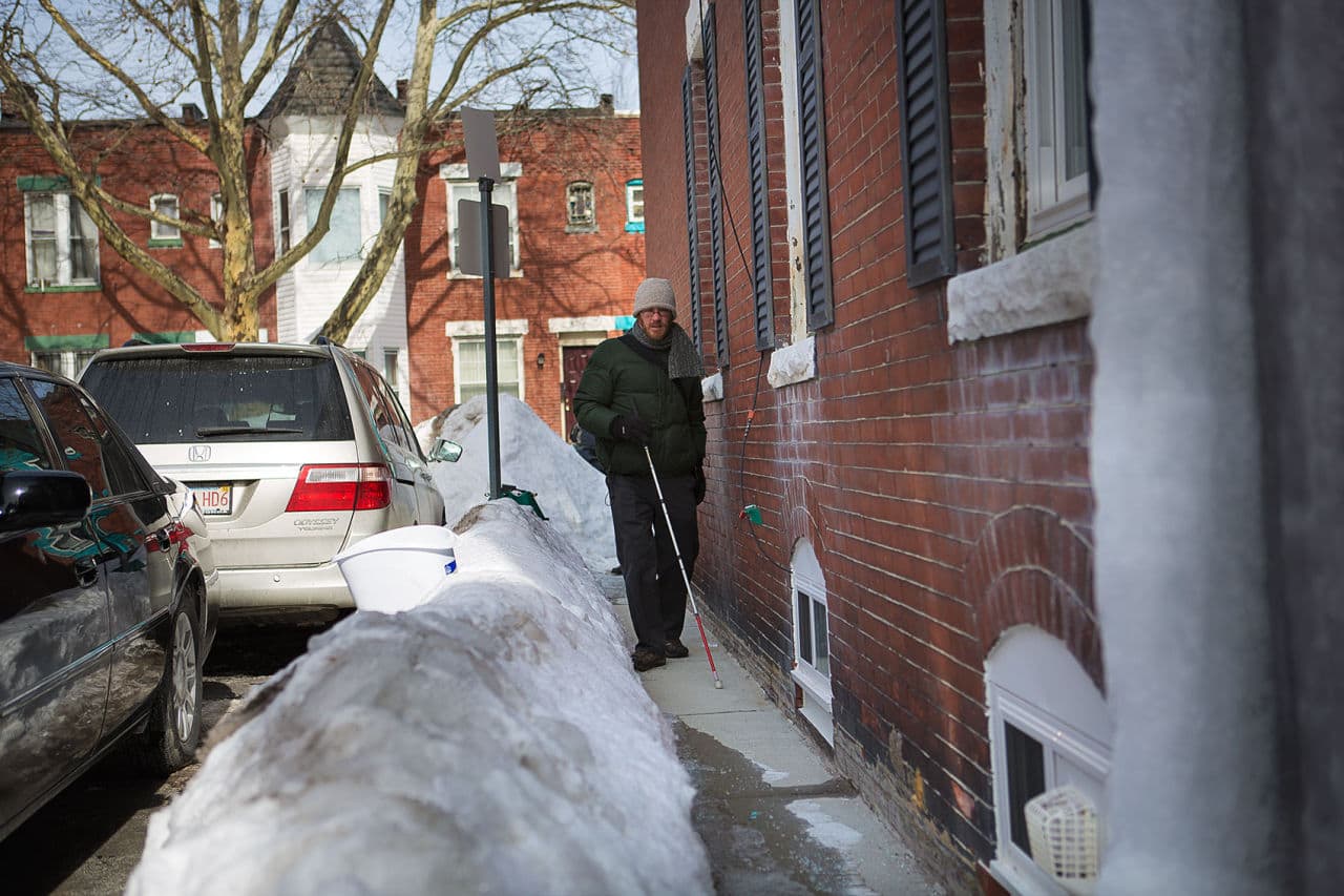 Robidoux walks down an icy path on his home street, Greenwich Court. (Jesse Costa/WBUR)