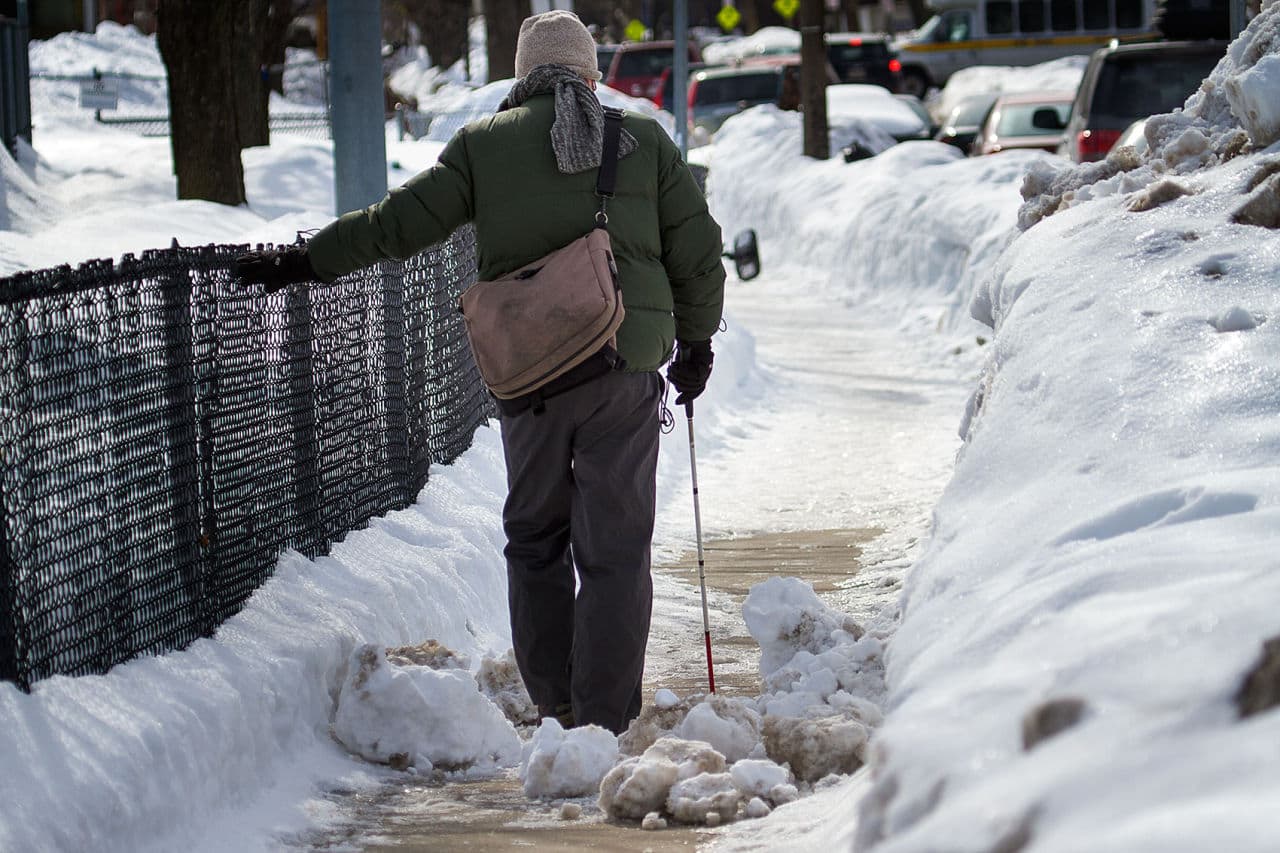 Kyle Robidoux walks trhough an icy obstacle on Shawmut Avenue by Ramsay Park on his way home in Roxbury. (Jesse Costa/WBUR)
