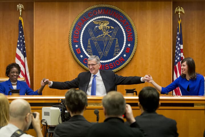 Federal Communication Commission (FCC) ChairmanTom Wheeler, center, joins hands with FCC Commissioners Mignon Clyburn, left, and Jessica Rosenworcel, before the start of their open hearing in Washington, Thursday, Feb. 26, 2015.  (AP)