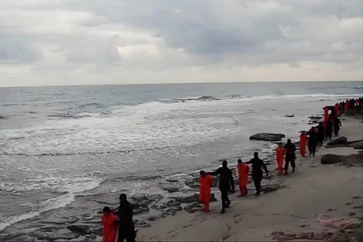 In this file image made from a video released Sunday, Feb. 15, 2015 by militants in Libya claiming loyalty to the Islamic State group purportedly shows Egyptian Coptic Christians in orange jumpsuits being led along a beach, each accompanied by a masked militant. (AP)