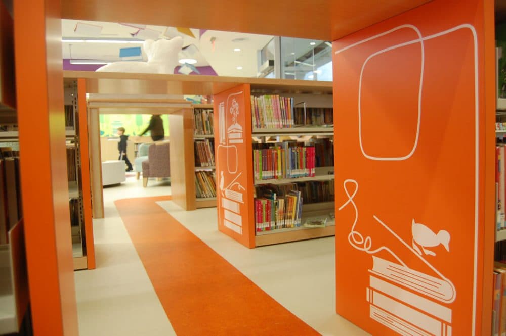 Gaps between shelves in the Children’s Library become tunnels to explore. (Greg Cook)